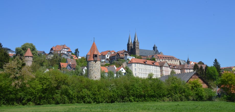 Auf diesem Bild wird die Stadtansicht gezeigt, wenn man in den Ederauen am Aussichtspunkt "Vier-Türme-Blick" steht. Blauer Himmel und hoch oben drohnt der imposante Dom St. Peter. Rundherum sieht man die (Fachwerk-)Häuser der Fritzlarer Altstadt und einige der noch gut erhaltenen Wehrtürme Fritzlars. Im Vordergrund der Wehrturm die Kanzel.