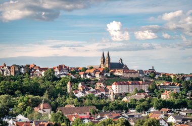 Stadtansicht Fritzlar Hier sieht man die Stadt Fritzlar aus südlicher Sicht bei blauem Himmer und ein paar Wolken. Oben drohnt der imposante Dom St. Peter. Rundherum kann man einige der noch gut erhaltenen Wehrtürme erblicken sowie viele (Fachwerk-)Häuser der Fritzlarer Altstadt.